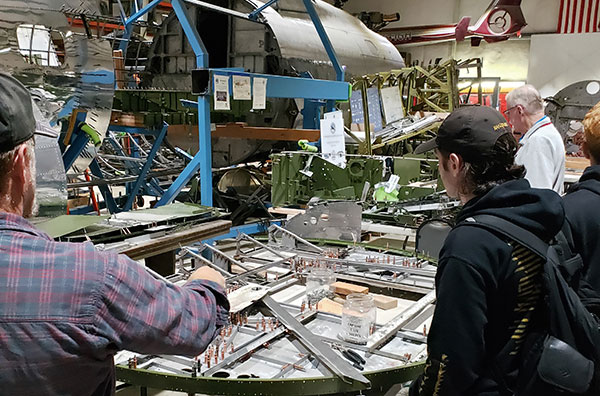 People touring the hangar and looking at parts of the B-17