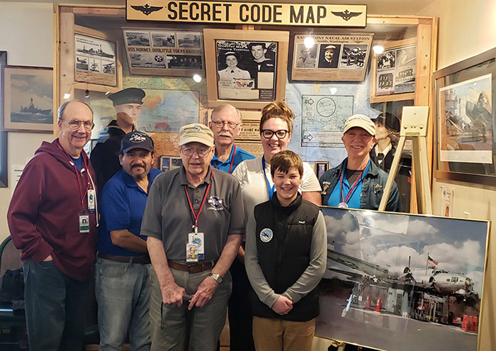 Volunteers in the museum by the Secret Code Map exhibit